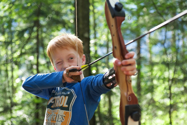 Portrait of a boy with bow and arrow in an adventure park
