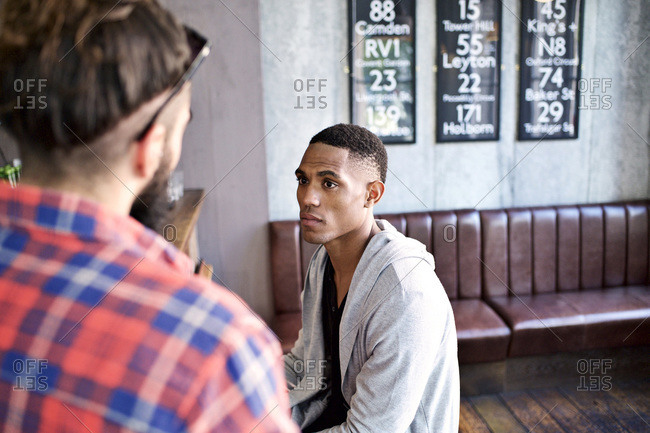 Two men having a conversation in a bar