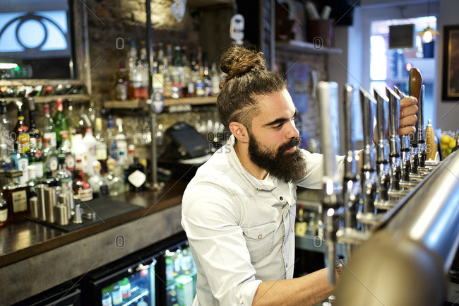 Male bartender pouring a draft beer