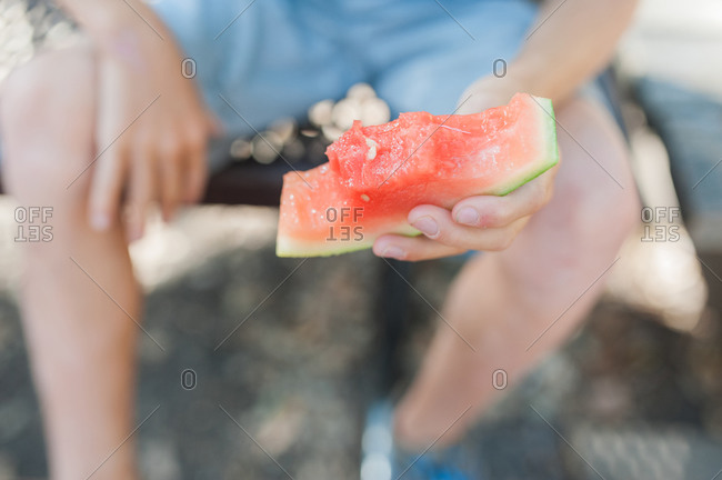 Hand of a little boy holding a watermelon rind
