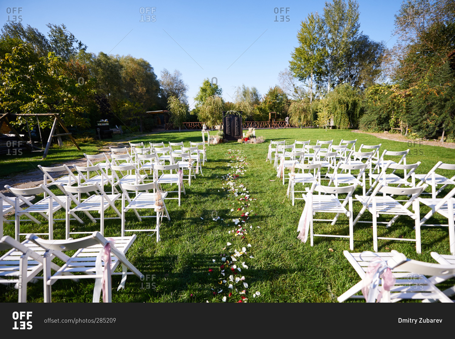 White folding chairs set up for an outdoor wedding ceremony stock photo