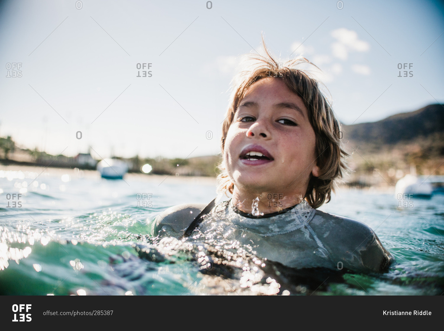 Boy in wetsuit treading water