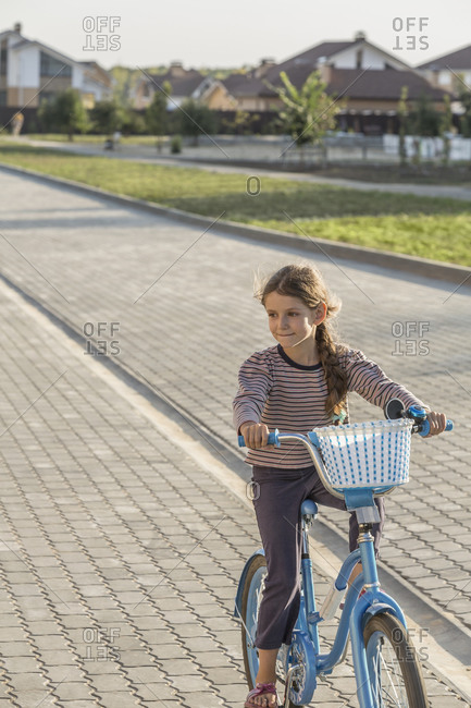 Girl cycling on footpath - Offset