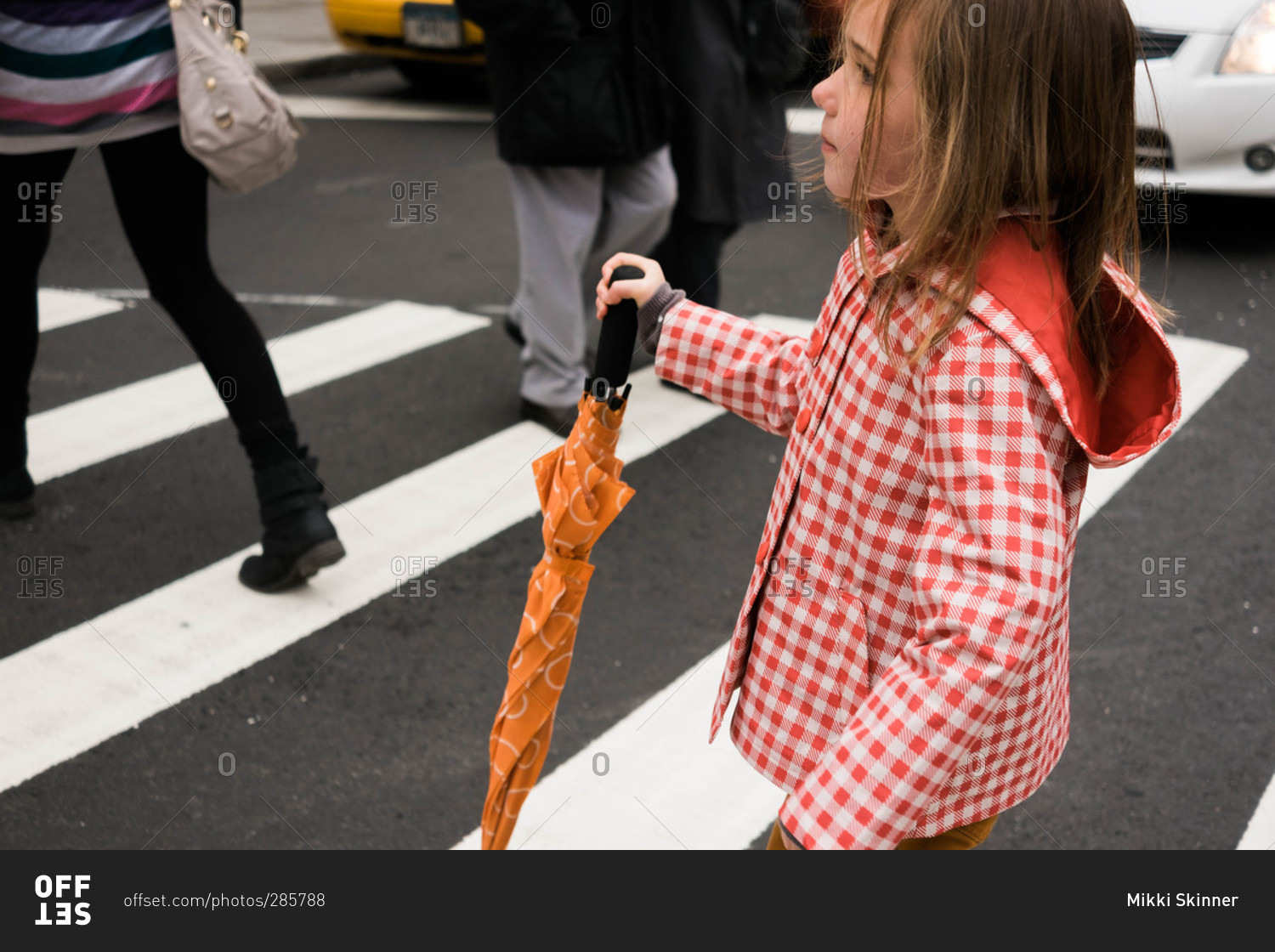 Girl with rain gear in crosswalk