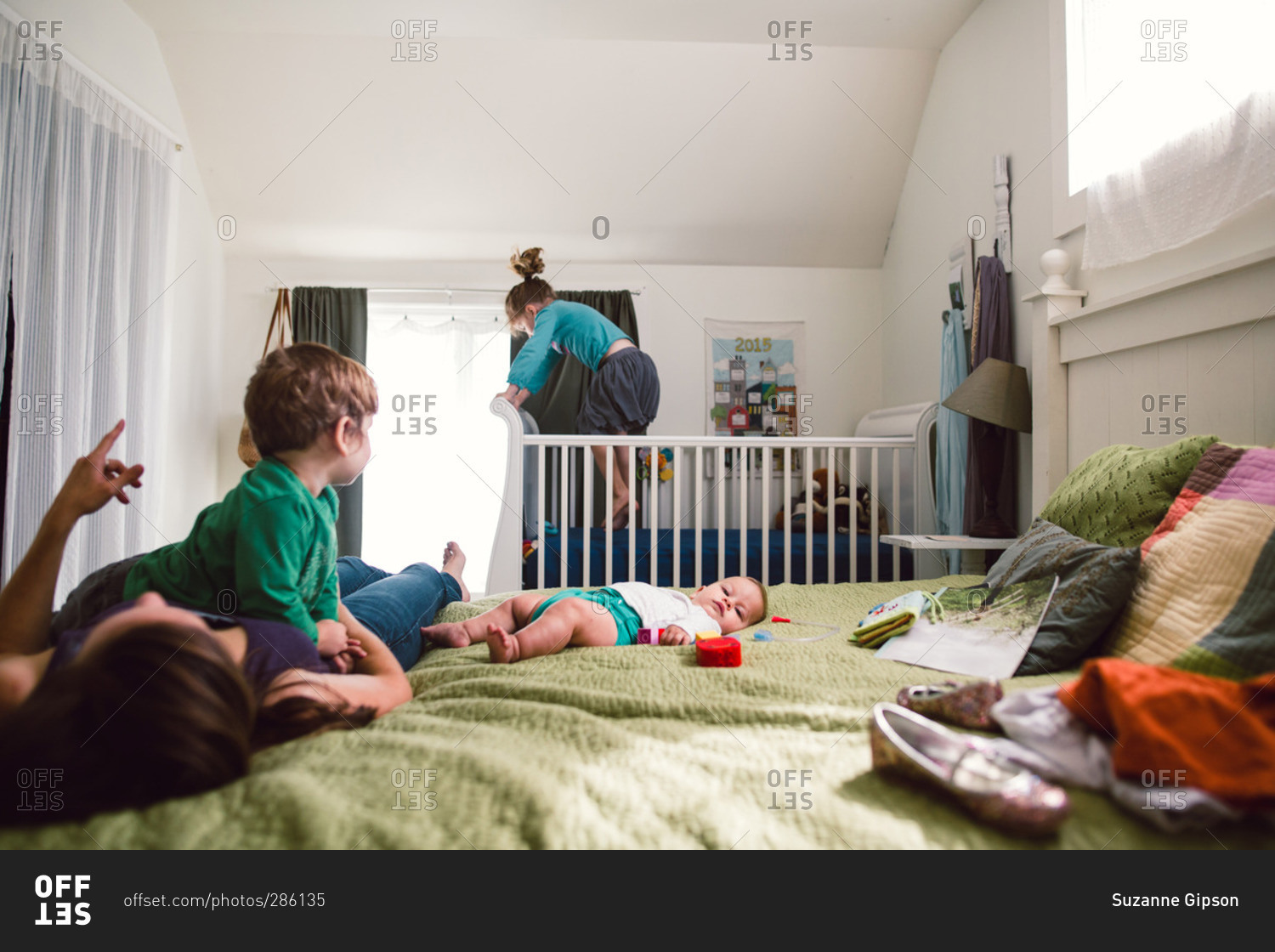 Kids playing in bed and jumping in baby's crib stock photo OFFSET