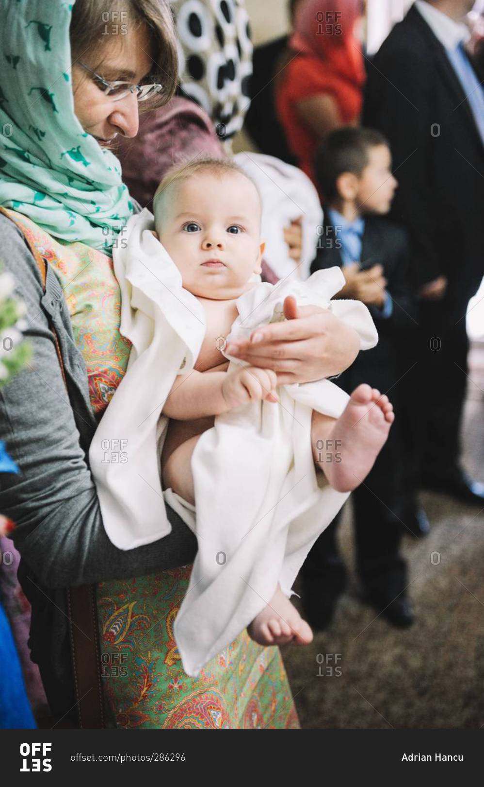 Baby boy held by his godmother during an Orthodox Christian Baptism in Chisinau, Moldova