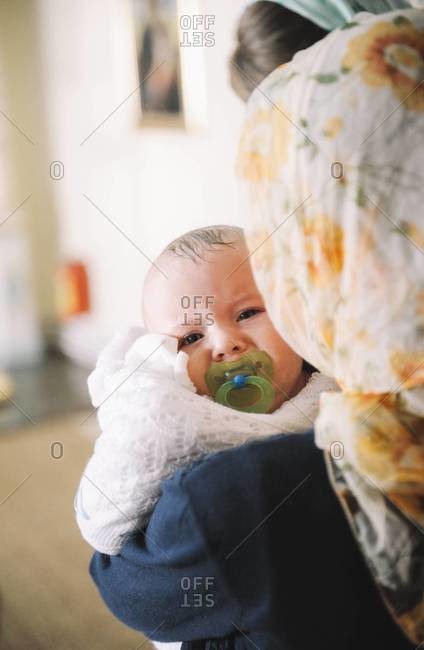 Mother holding wet young boy after Orthodox Christian Baptism in Chisinau, Moldova