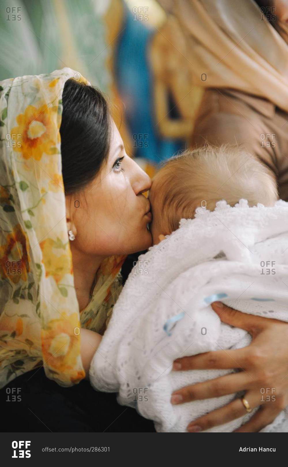 Mother kissing her baby after Orthodox Christian Baptism in Chisinau, Moldova