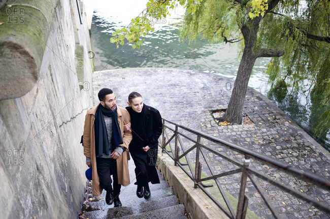 High angle view of couple walking up stairs next to Seine River, Paris, France
