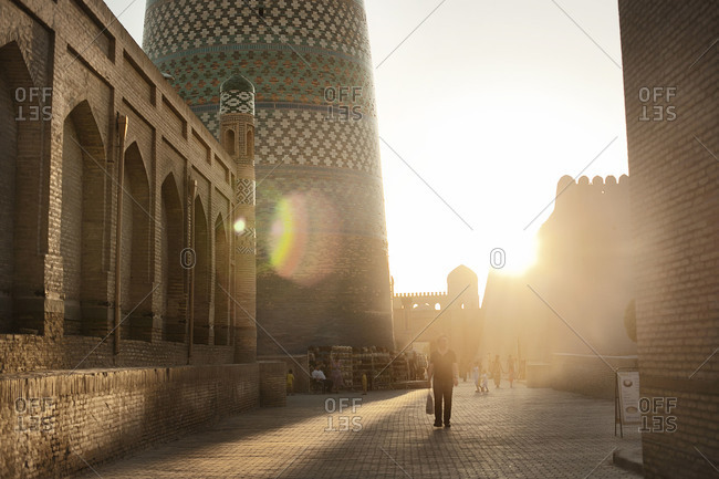 People walking in the ancient city in Khiva, Uzbekistan at sunset