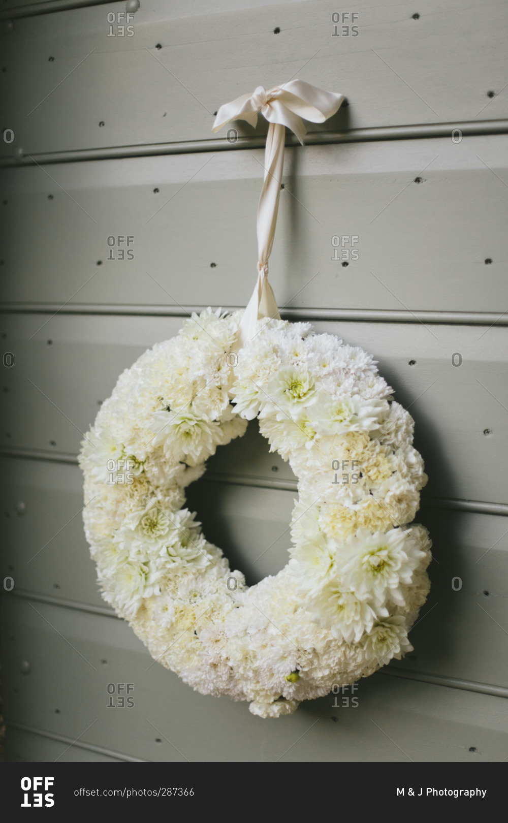 Floral wedding wreath hung with ribbon