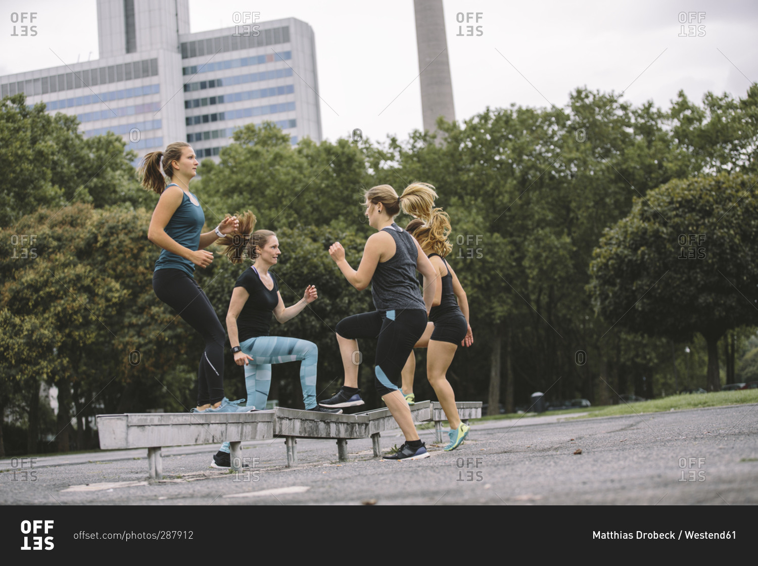 Four women doing step ups during an outdoor workout