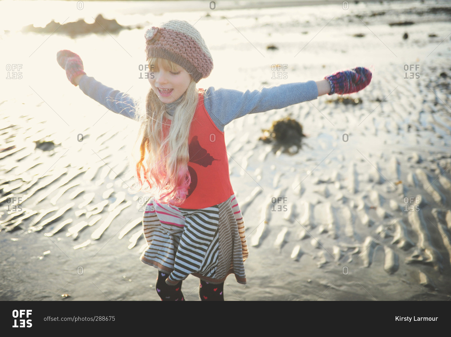 Girl in cool weather clothes on beach