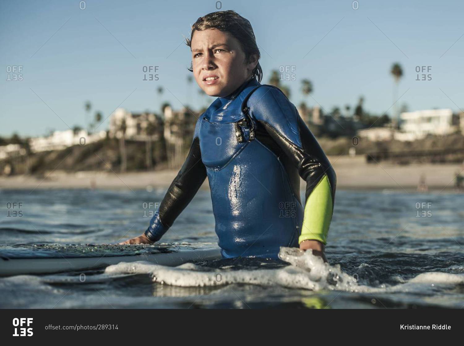 Boy looking out at waves while surfing in San Clemente, California