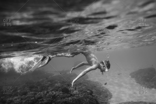Boy diving down while snorkeling in Huatulco, Mexico