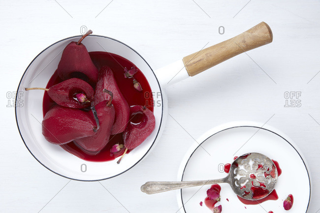 Wine, spice, and rose poached pears in an enamel pot