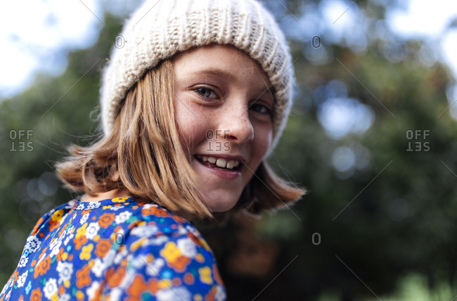 Portrait of smiling girl wearing woolen cap looking over her shoulder