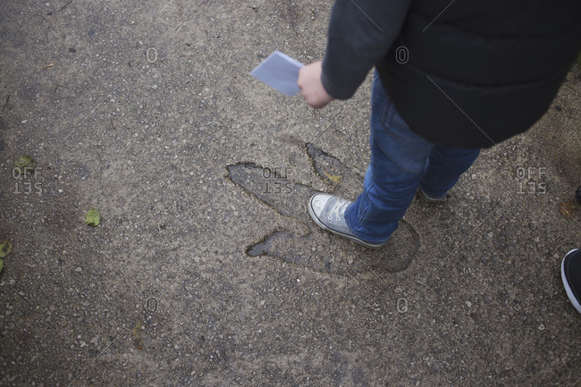 Blackpool, UK - November 1, 2015: Little boy standing in a dinosaur footprint