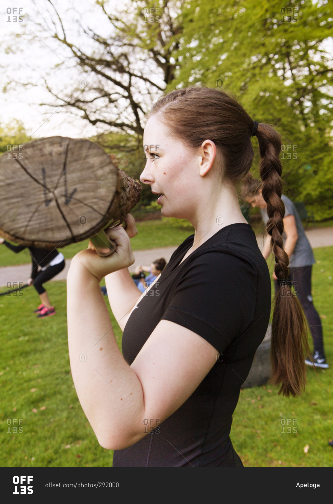 Close up of a young athletic woman weight lifting with a log