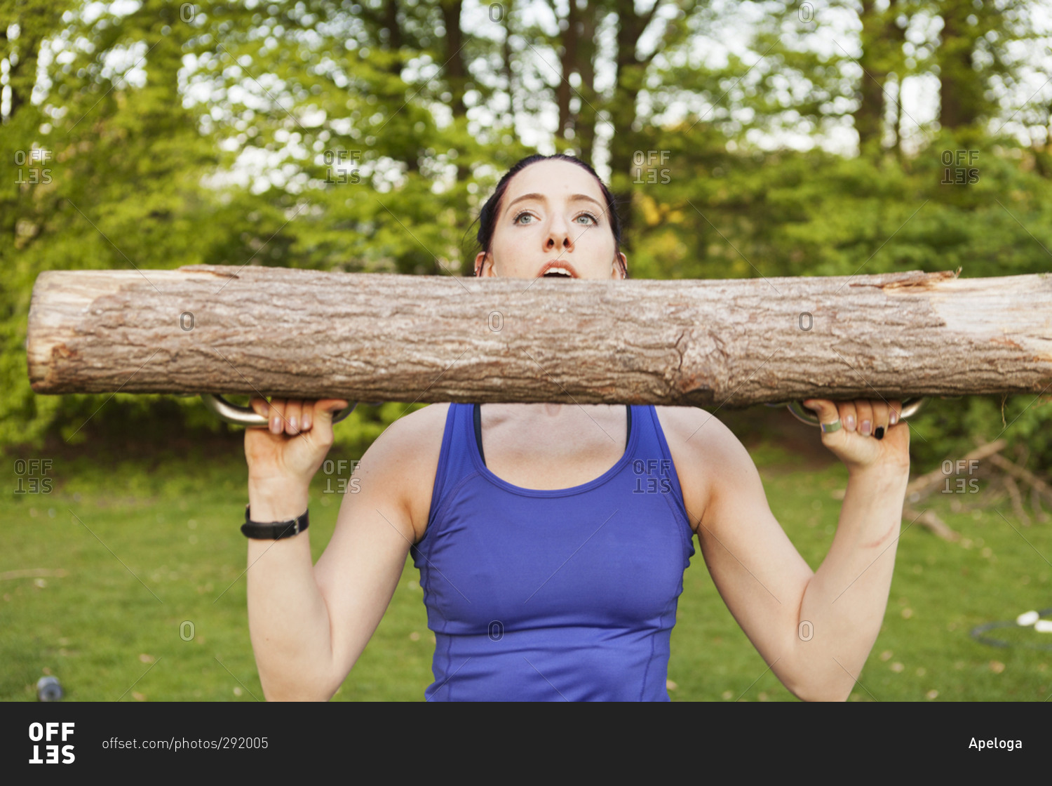 Close up of a young athletic woman lifting a log