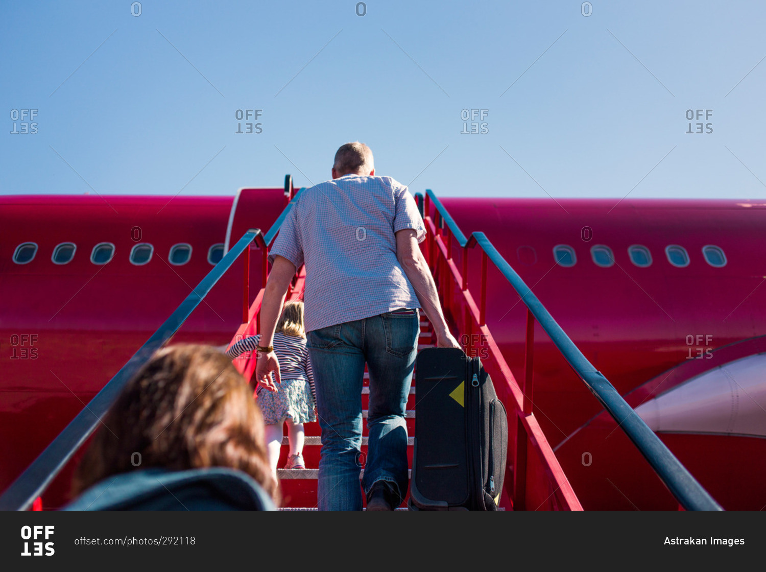 People climbing steps to board plane