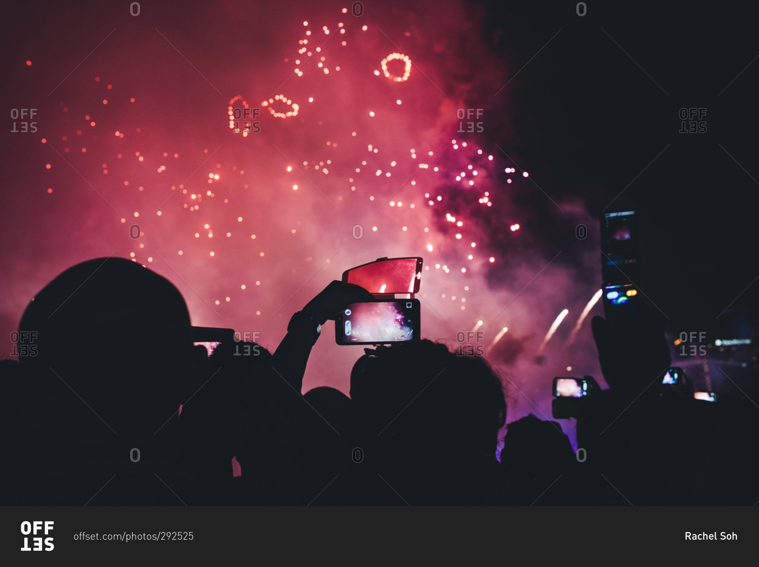 Crowd silhouetted by firework display
