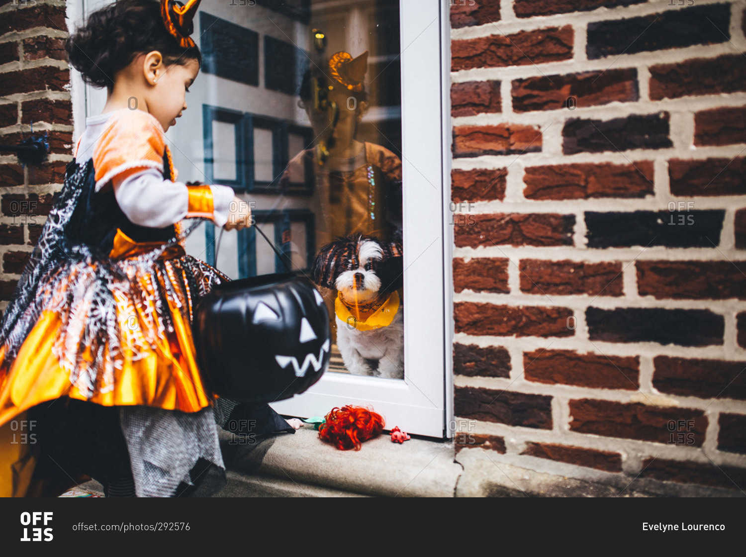 Girl and dog at front door on Halloween