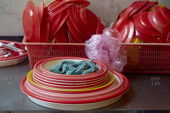 Red plastic dishware drying in a dish drainer
