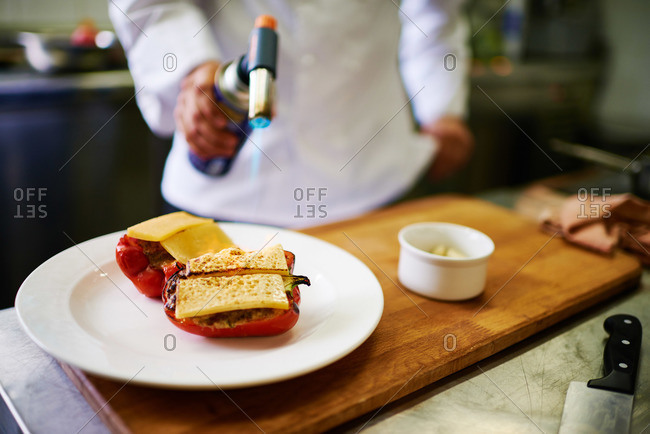 Chef melting cheese with blowtorch