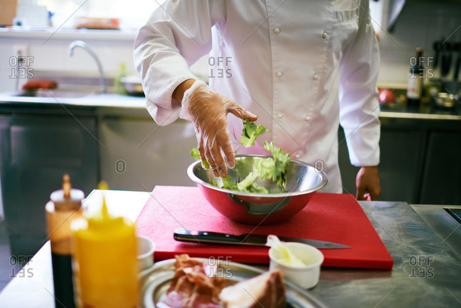 Chef tossing salad by hand