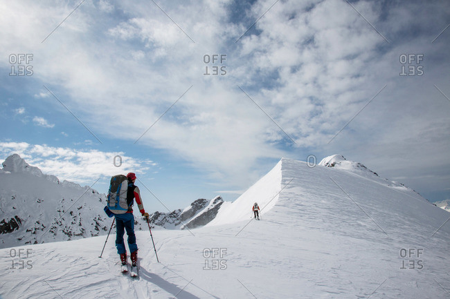 Skiers along a steep ridge during the Spearhead Traverse in the Coast Mountains of British Columbia, Canada