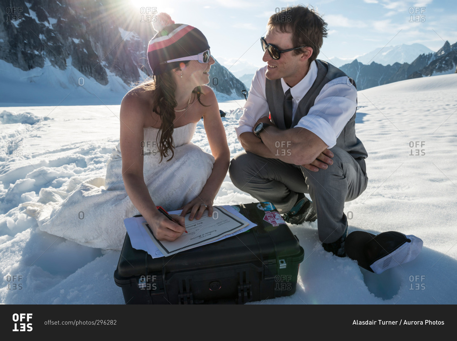 Adventurous bride and groom sign the wedding certificate after getting married on a glacier in Denali National Park