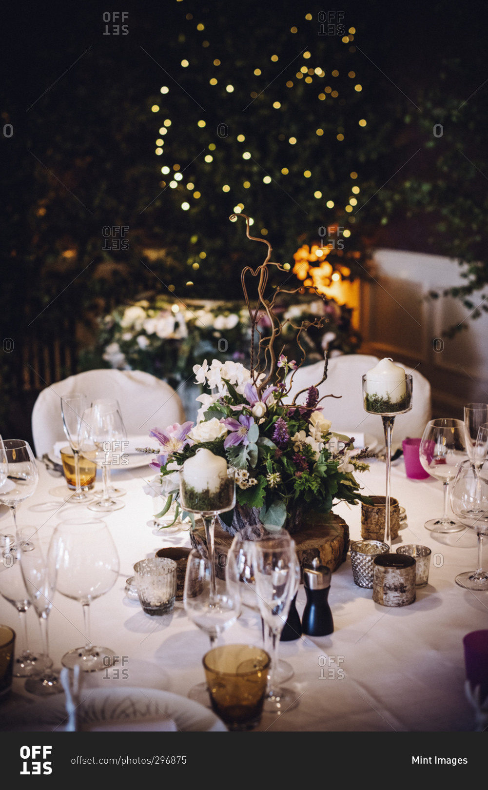 A table laid for a special occasion, with a floral centerpiece and candles, at night
