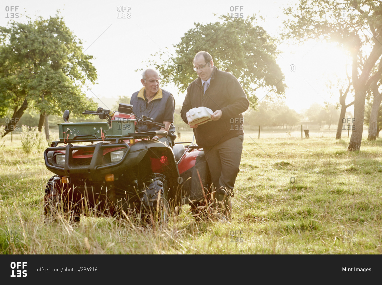 A farmer and a business manager discussing pesticides in a field