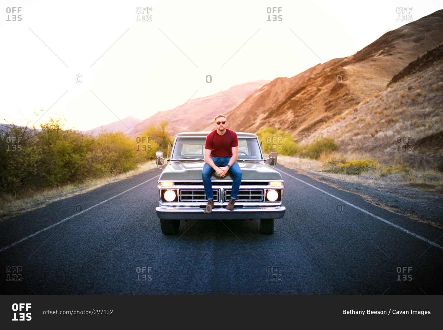 Man posing on hood of vintage pick-up truck