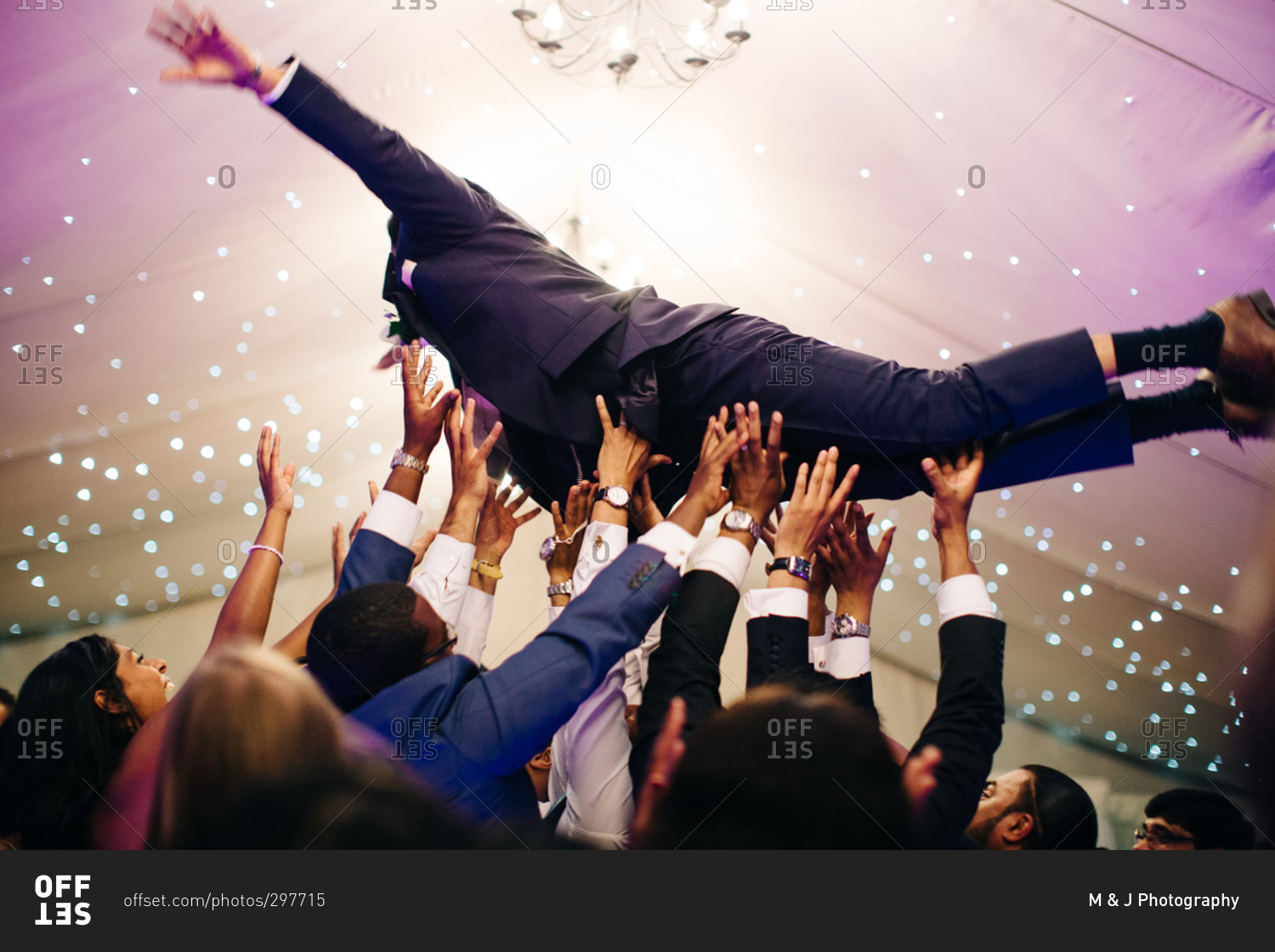 Wedding guests catch groom as he dives into crowd