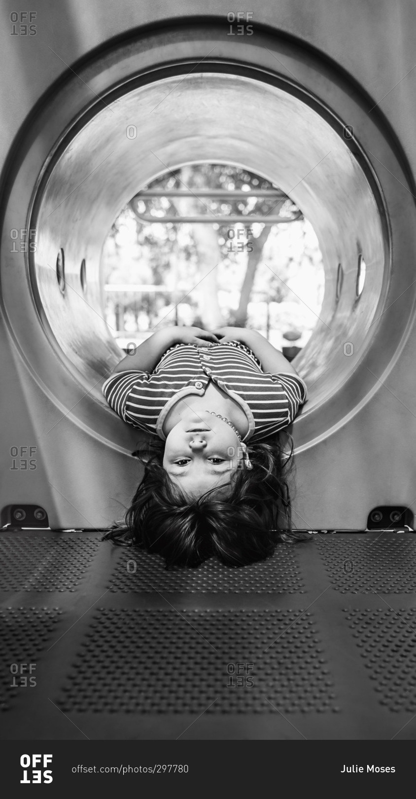 little-girl-hanging-upside-down-in-a-playground-tunnel-stock-photo-offset