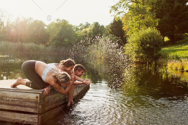 Women splashing in lake off dock