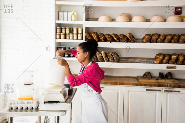 Miami, Florida, USA - September, 2015: Woman scooping flour in bakery