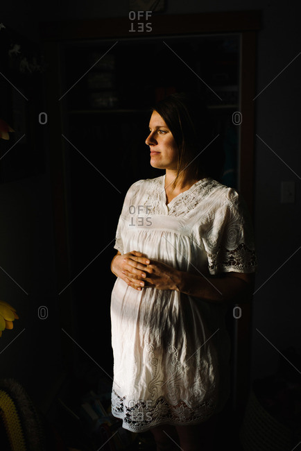 Pregnant woman in sunlight indoors