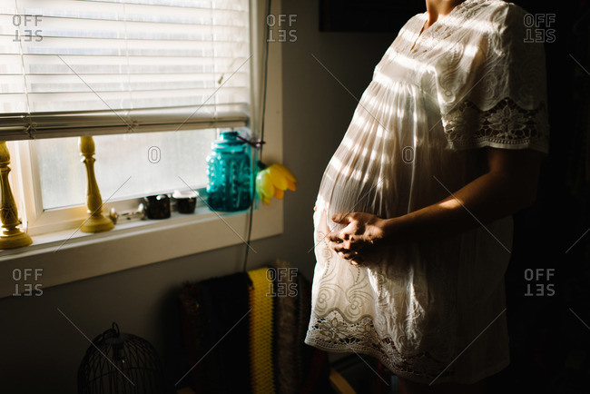 Pregnant woman in sunlight from window