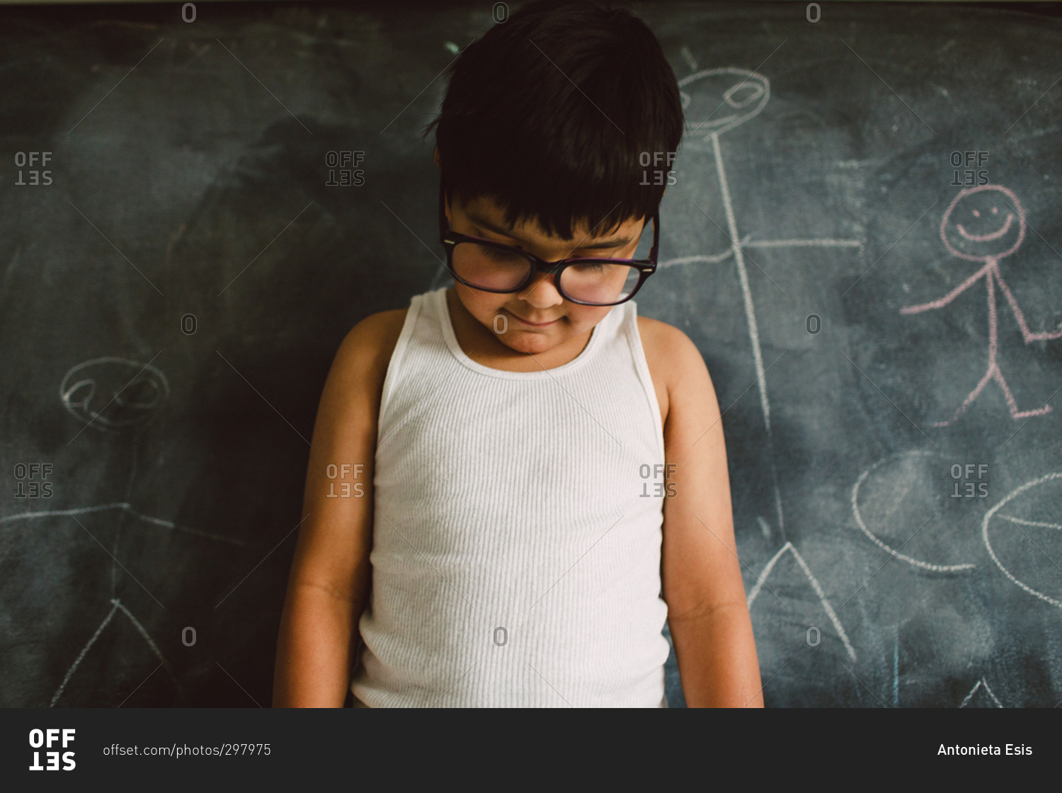 Little boy standing in front of a chalkboard