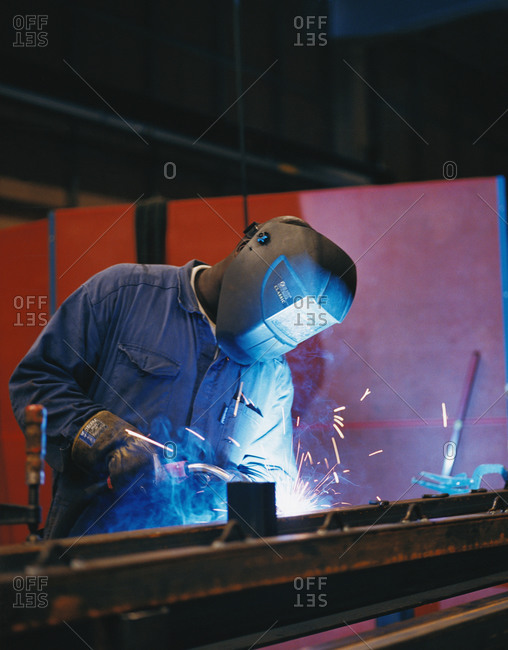 An industrial welder welding iron in workplace