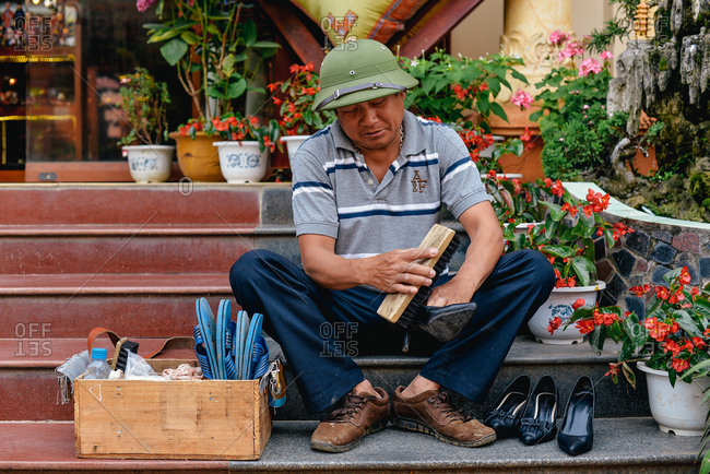 Sapa, Vietnam - July 13, 2015: A shoe-shiner doing his daily shining on the side of the road