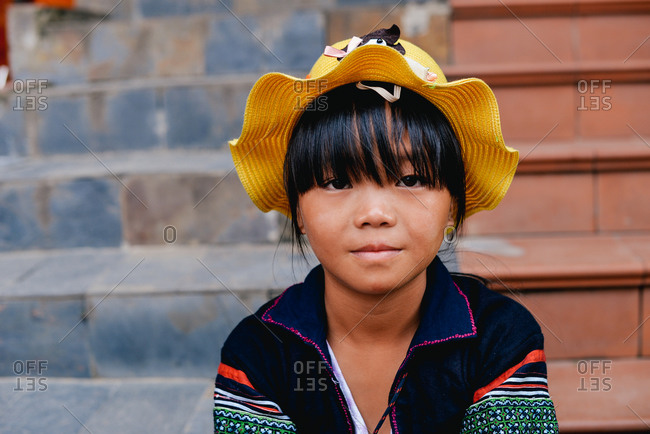 Sapa, Vietnam - July 13, 2015: A little girl sits on the stairs of her family's store