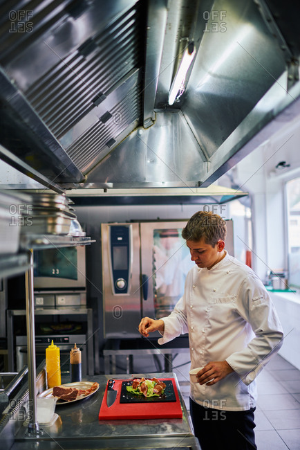 Chef plating food in a commercial kitchen