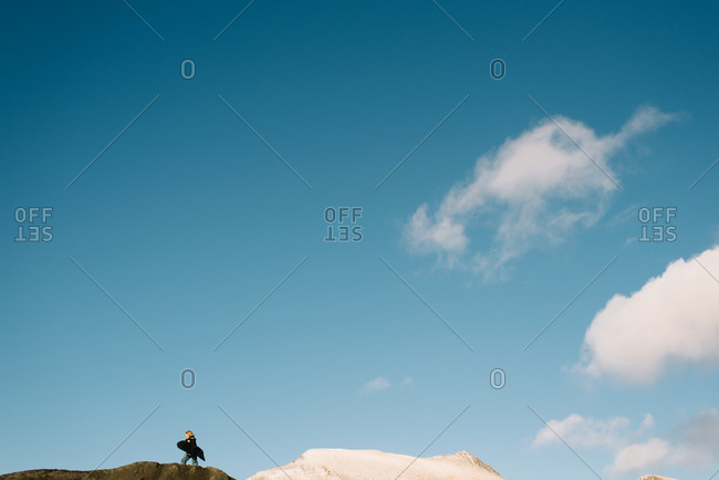 Boy on top of sand hill with sled