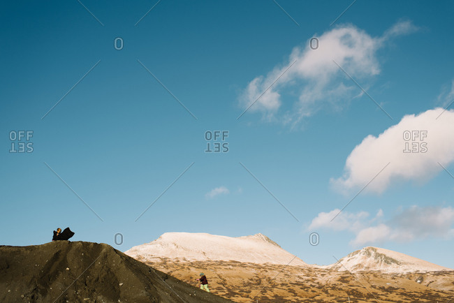Two children playing on sand dune with sleds