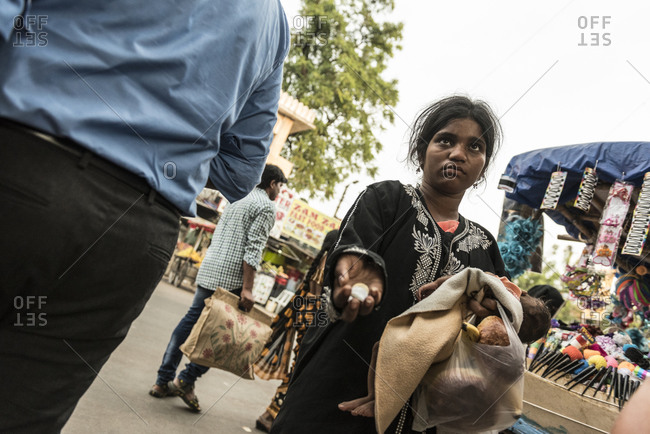 Hyderabad, India - October 8, 2015: Young mother with infant begging at market in India