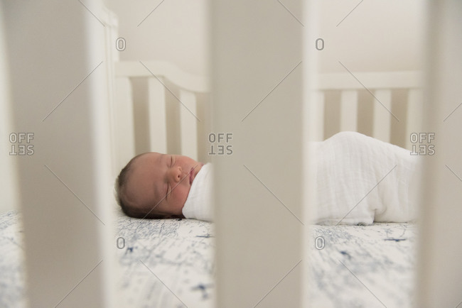 Peaceful newborn baby asleep in crib